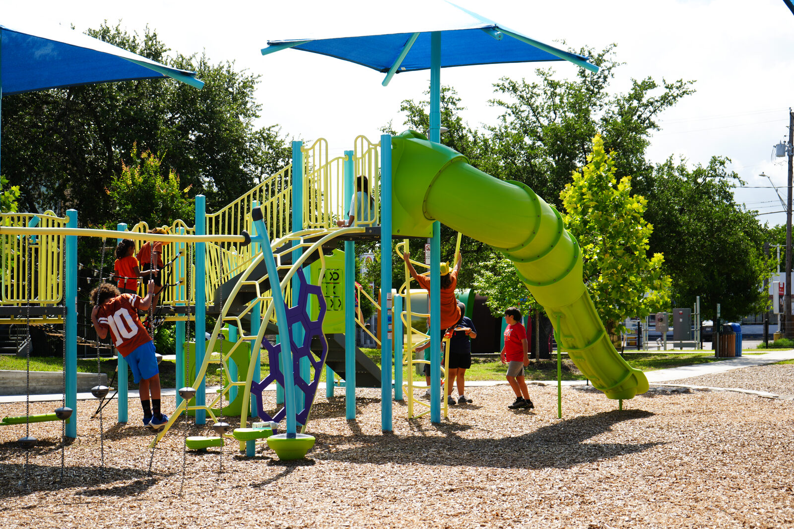 Children playing on a colorful playground slide and climbing structure